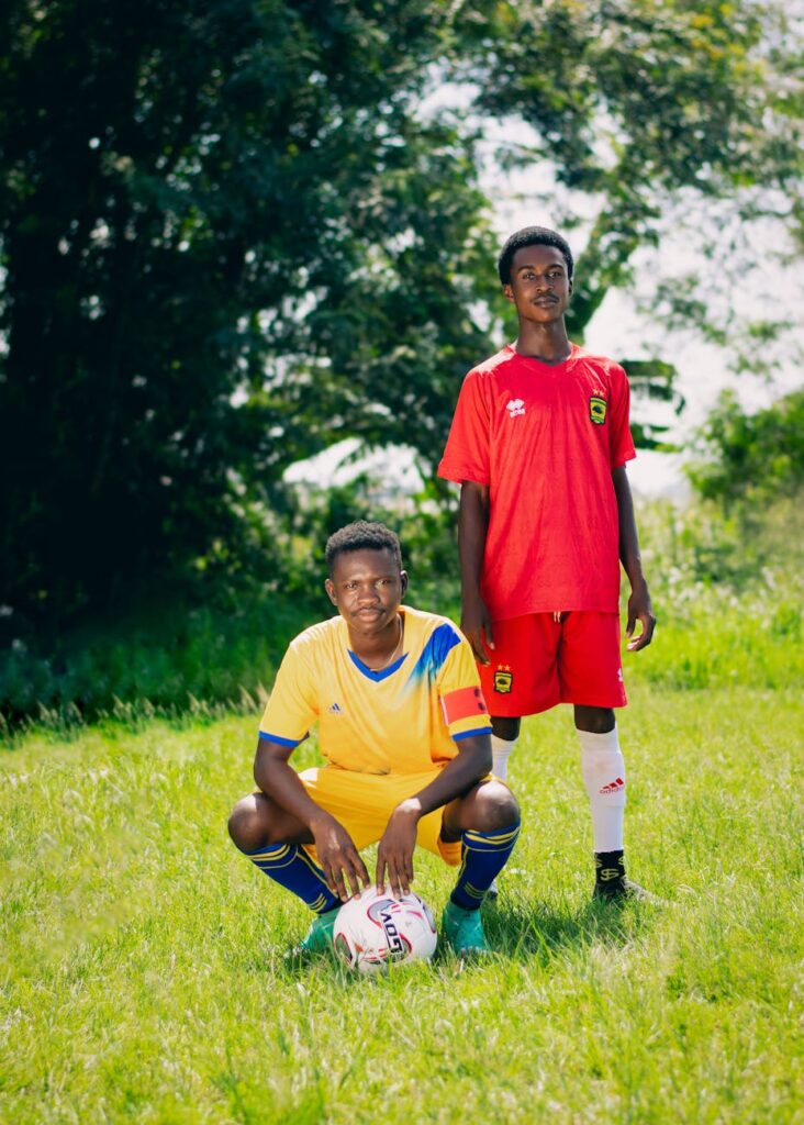 two young soccer players standing on a grass field