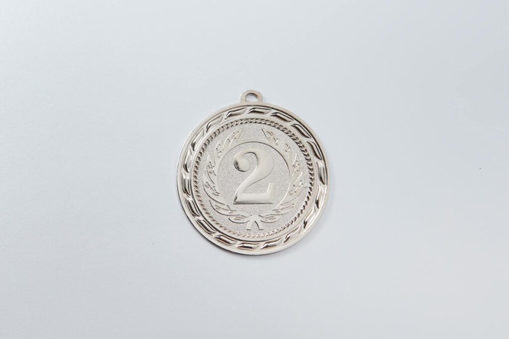 silver round coin on white surface